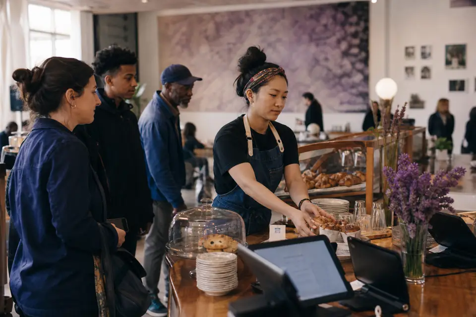 Staff member restocking a café counter inside a community arts center
