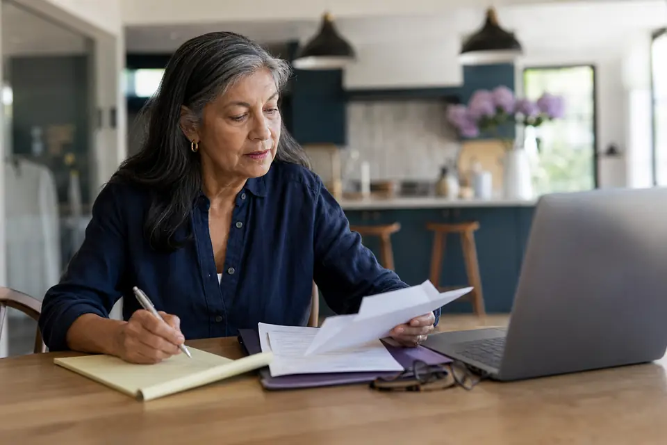 Nonprofit treasurer at home reviewing an IRS letter and taking notes