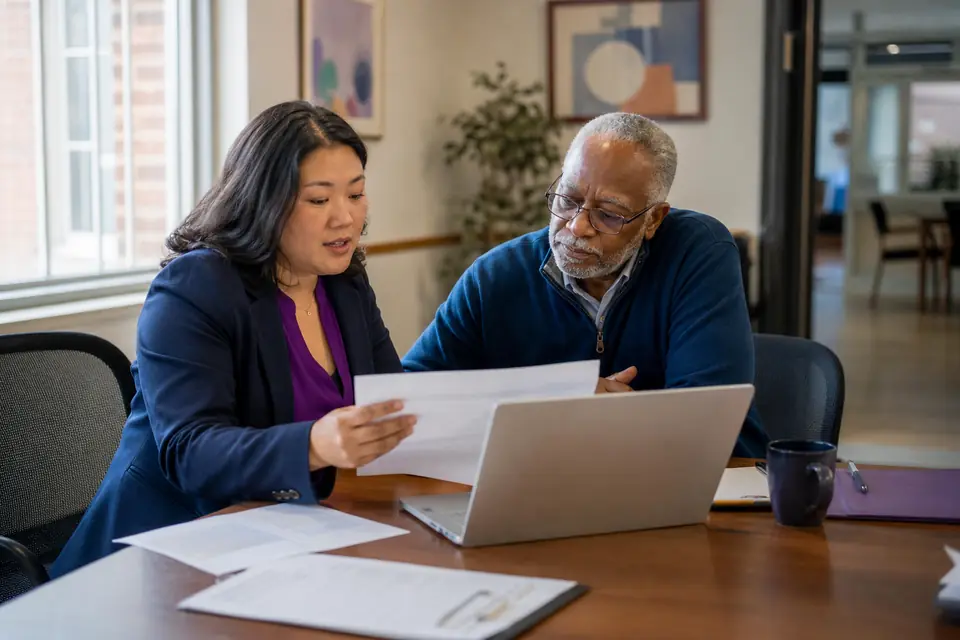 Nonprofit director and preparer reviewing a draft annual return together at a table